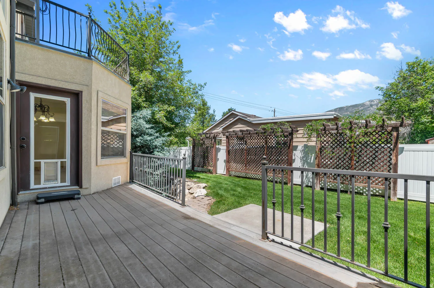 Expansive rear deck featuring composite wood-finish decking and wrought iron railing