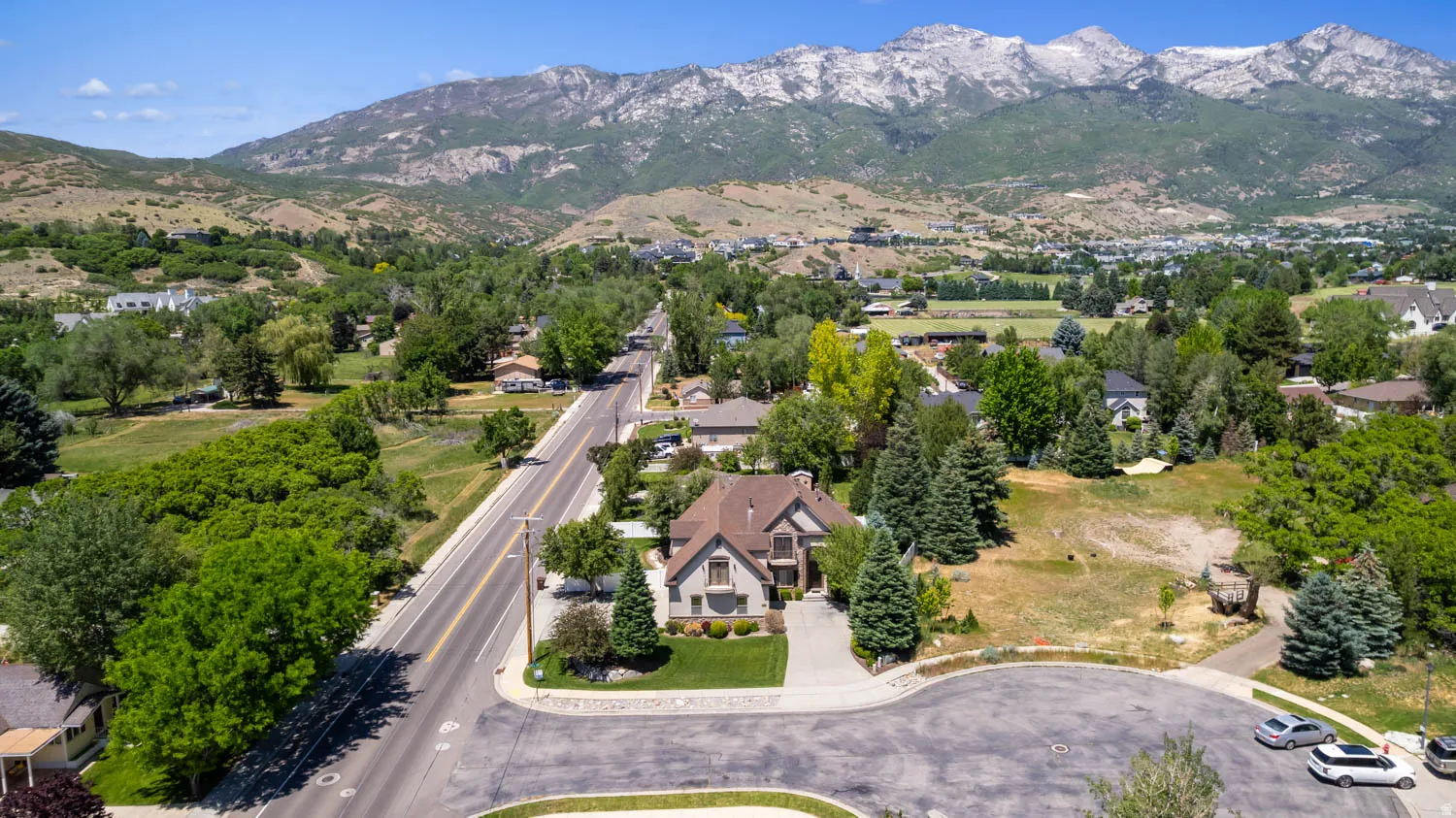 Mountain backdrop with a residential street, a cul-de-sac, and mature trees