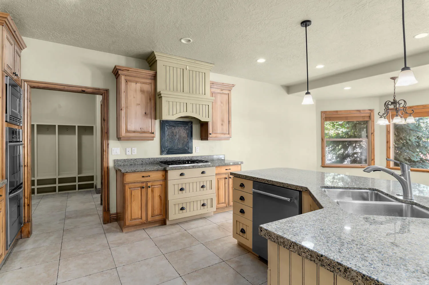 Kitchen featuring granite countertops, stainless steel appliances, a double basin sink with a gooseneck faucet, light wood cabinetry, and recessed lighting