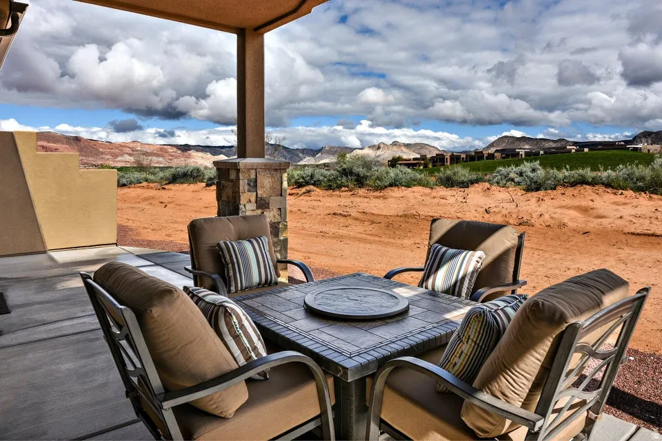 Covered patio with a concrete slab, a stone-clad support column, and stucco exterior walls