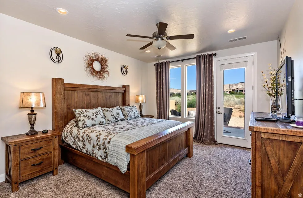 Carpeted bedroom featuring a ceiling fan with integrated lighting, recessed lighting, and a glass-paneled exterior door