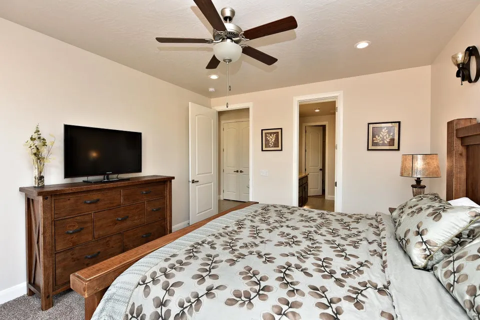 Room featuring a ceiling fan with integrated lighting, recessed ceiling lights, and two doorways