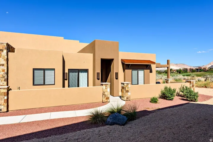 Stucco exterior with stone accents and a covered entryway