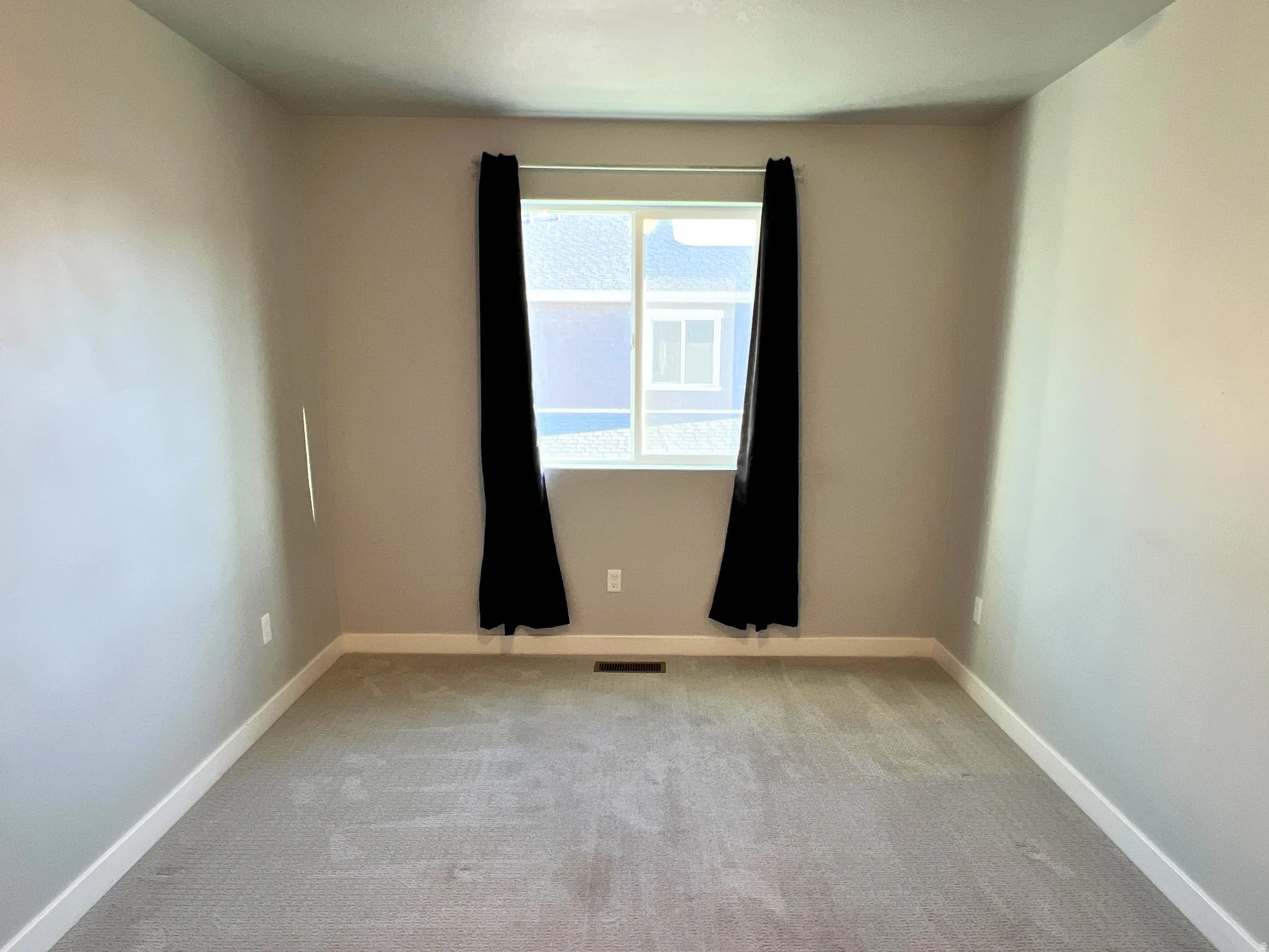 Neutral-toned walls complement plush grey carpeting