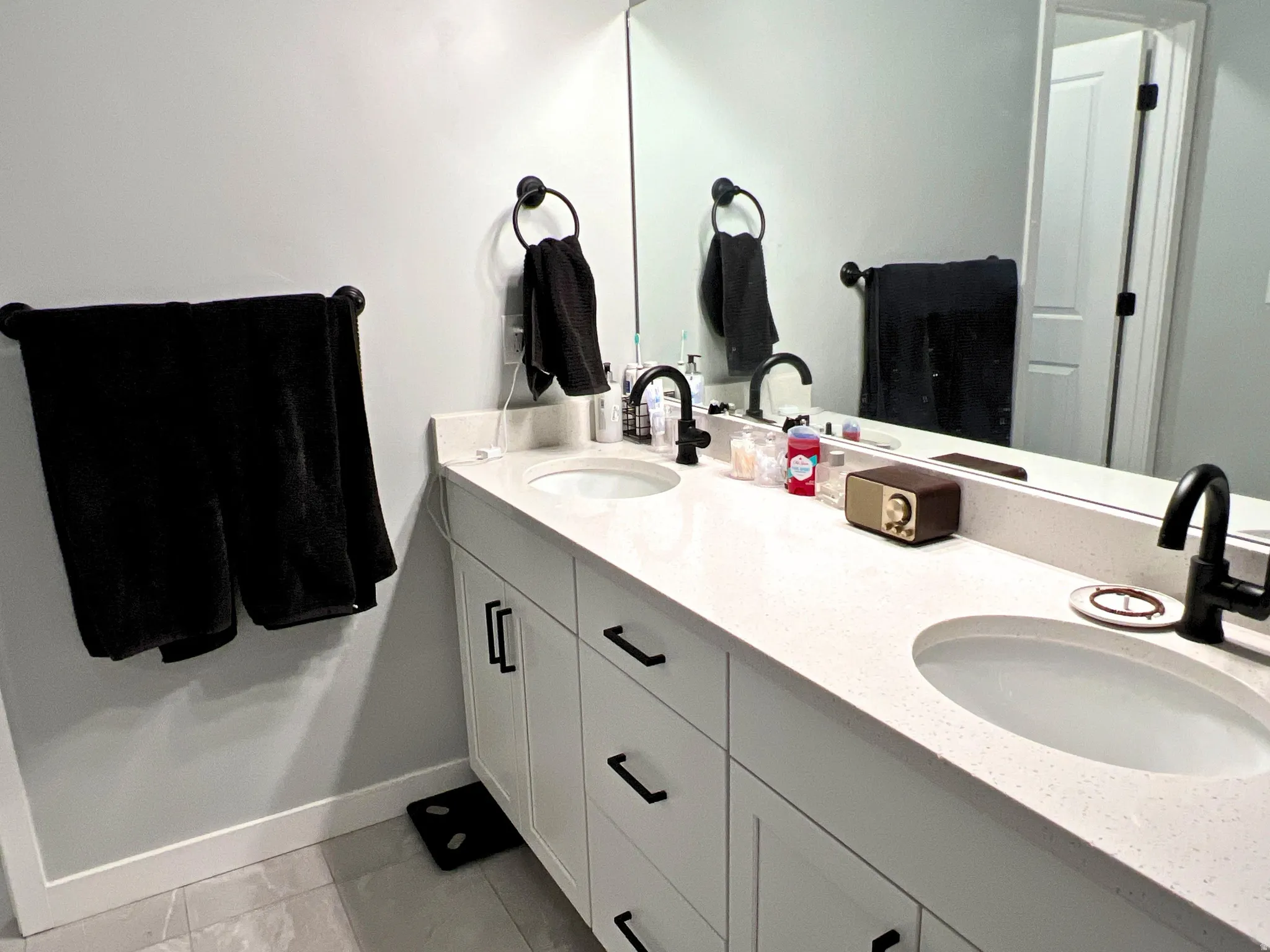Dual vanity with white cabinetry, matte black hardware, and integrated sinks