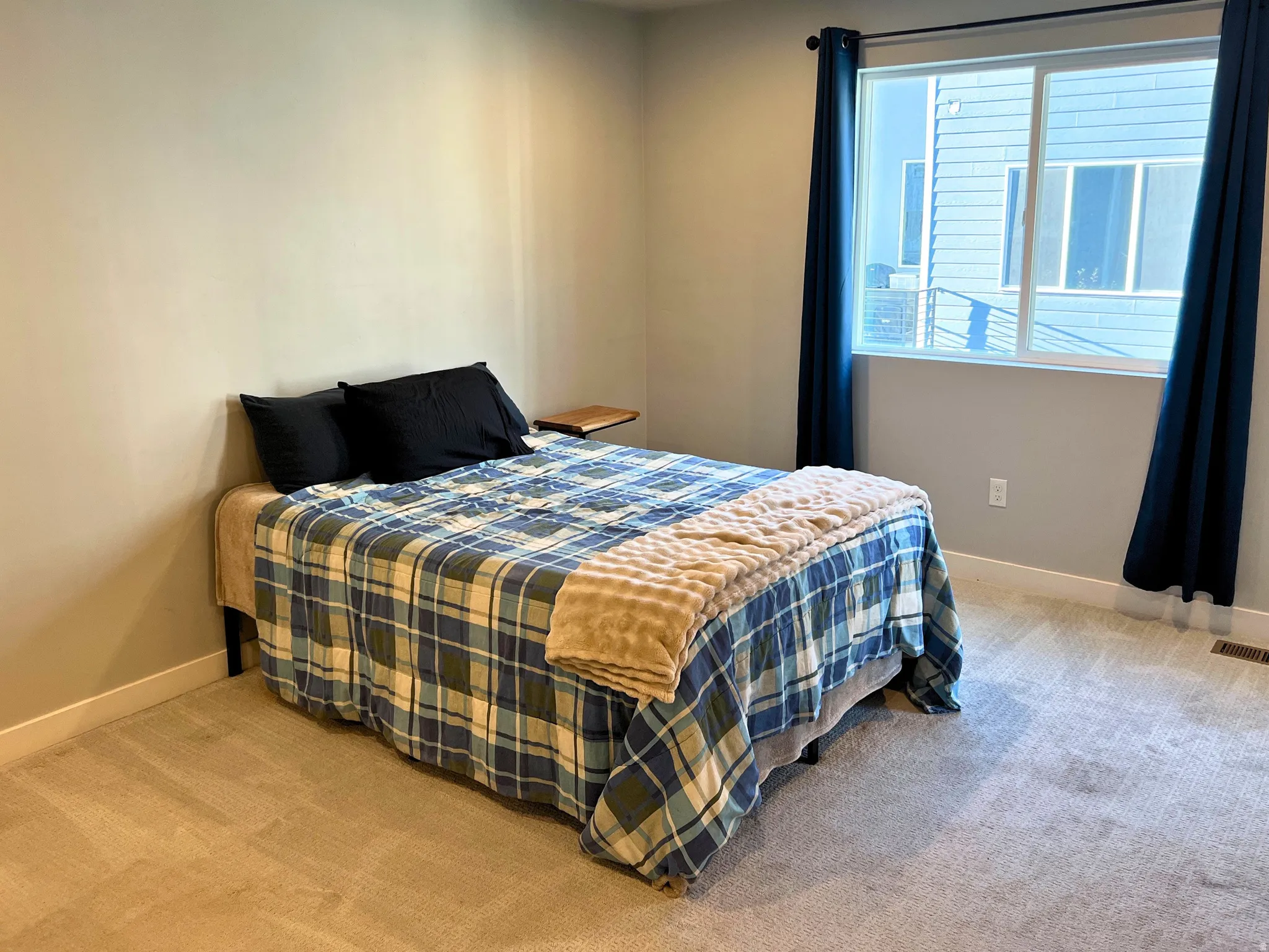 Carpeted bedroom with a large window, white trim, and light gray wall paint
