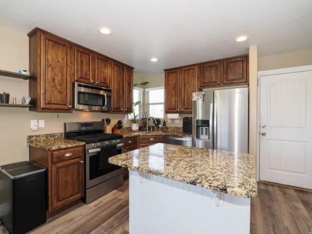 Kitchen featuring wood cabinetry, stainless steel appliances, and granite countertops