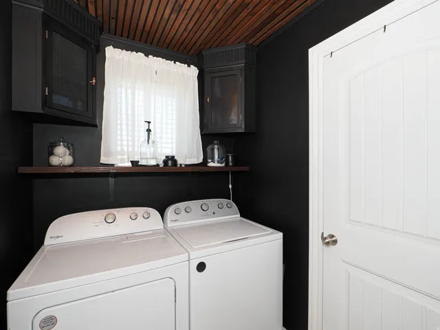 Dedicated laundry space with dark cabinetry and a wood-finish slatted ceiling