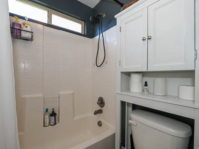 Bathtub with white tile surround and integrated soap dish