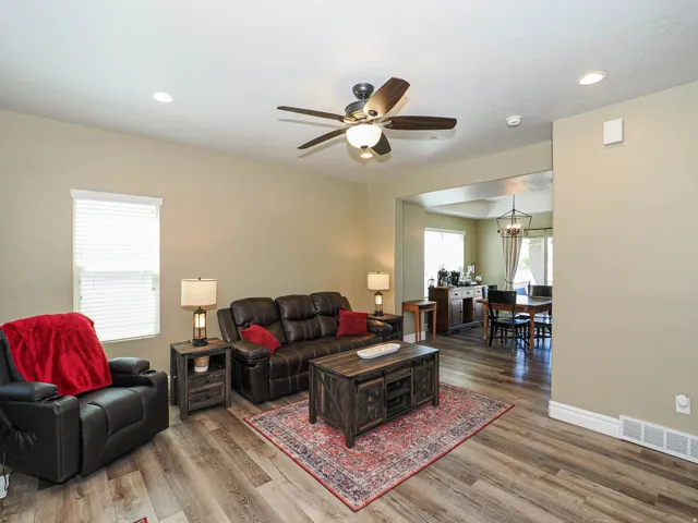 Spacious living area featuring wood-finish flooring, recessed lighting, and a ceiling fan