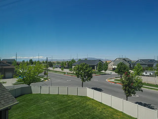 Expansive backyard with a manicured lawn, framed by a light-colored privacy fence