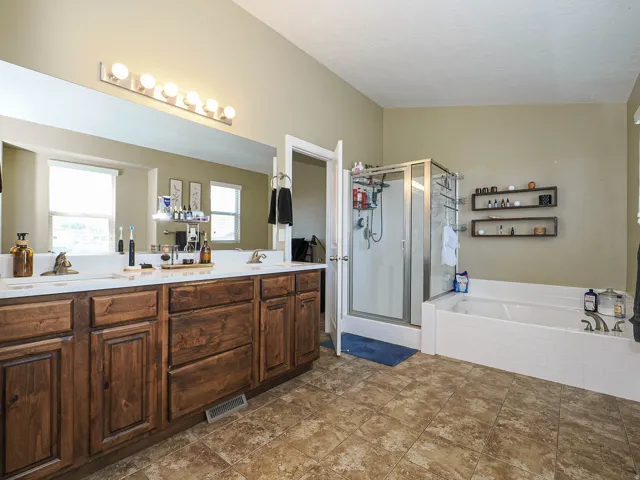 Bathroom featuring a dual vanity with wood cabinetry and white countertops