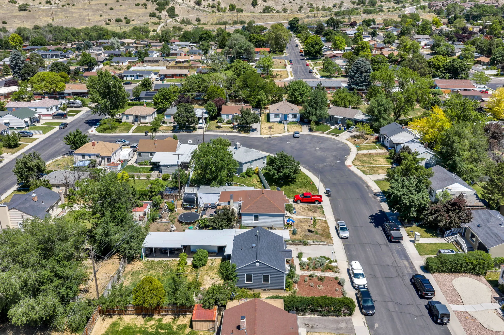 Residential neighborhood featuring multiple single-family homes, paved streets, and mature trees