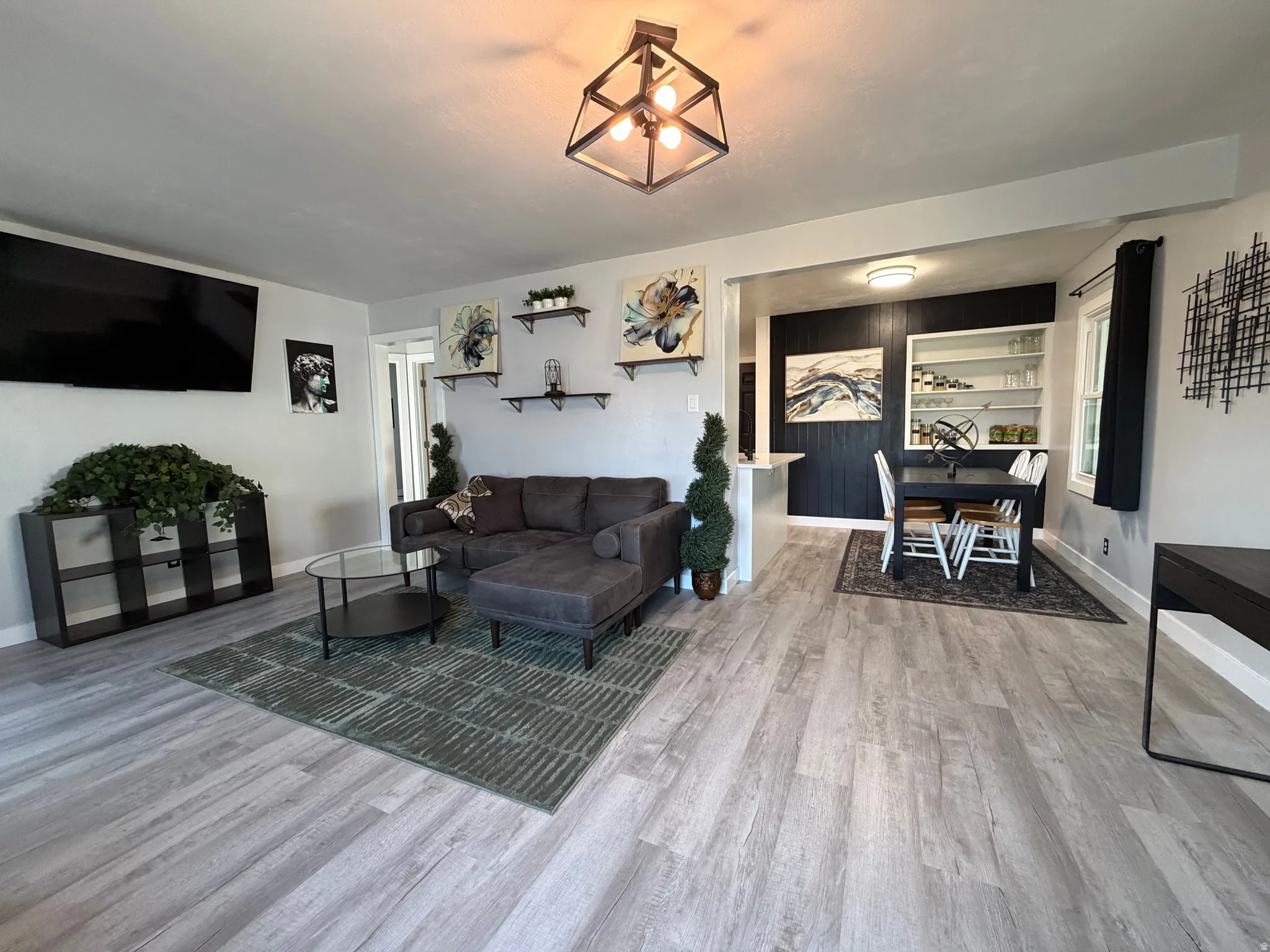 Light wood-finish flooring throughout, complemented by recessed lighting and a central decorative fixture