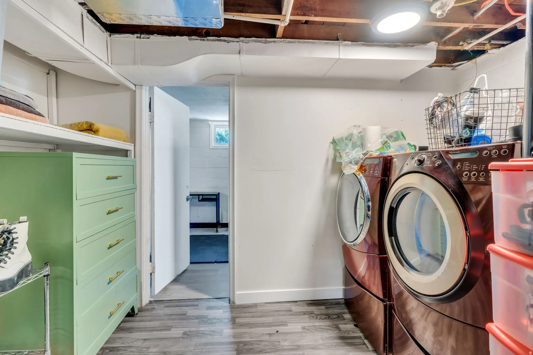 Dedicated utility area with wood-finish flooring, white walls, and built-in shelving