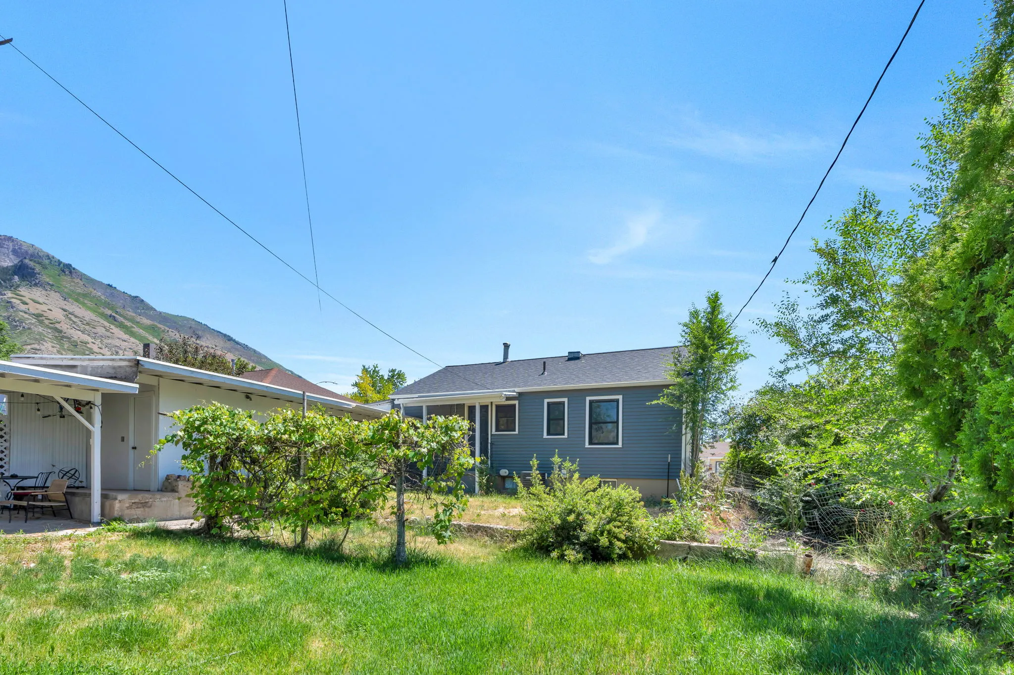 Expansive backyard featuring a pergola with new roof  and mountain backdrop