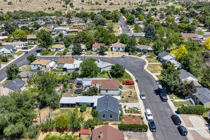 Residential neighborhood featuring multiple single-family homes, paved streets, and mature trees