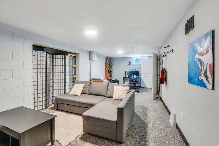 Finished interior space featuring recessed lighting, painted cinder block walls, and textured carpet flooring