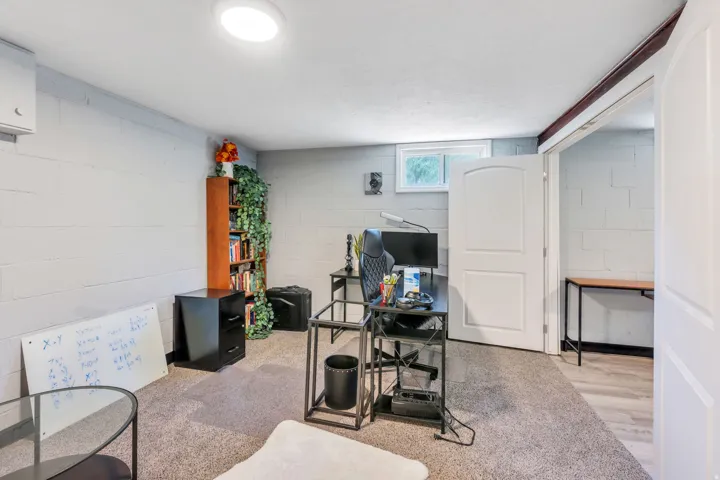 Versatile interior space featuring light gray painted block walls, a flush-mount ceiling light, and a window providing natural illumination