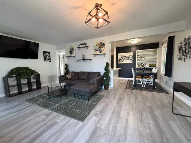 Light wood-finish flooring throughout, complemented by recessed lighting and a central decorative fixture