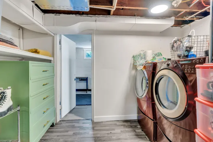 Dedicated utility area with wood-finish flooring, white walls, and built-in shelving