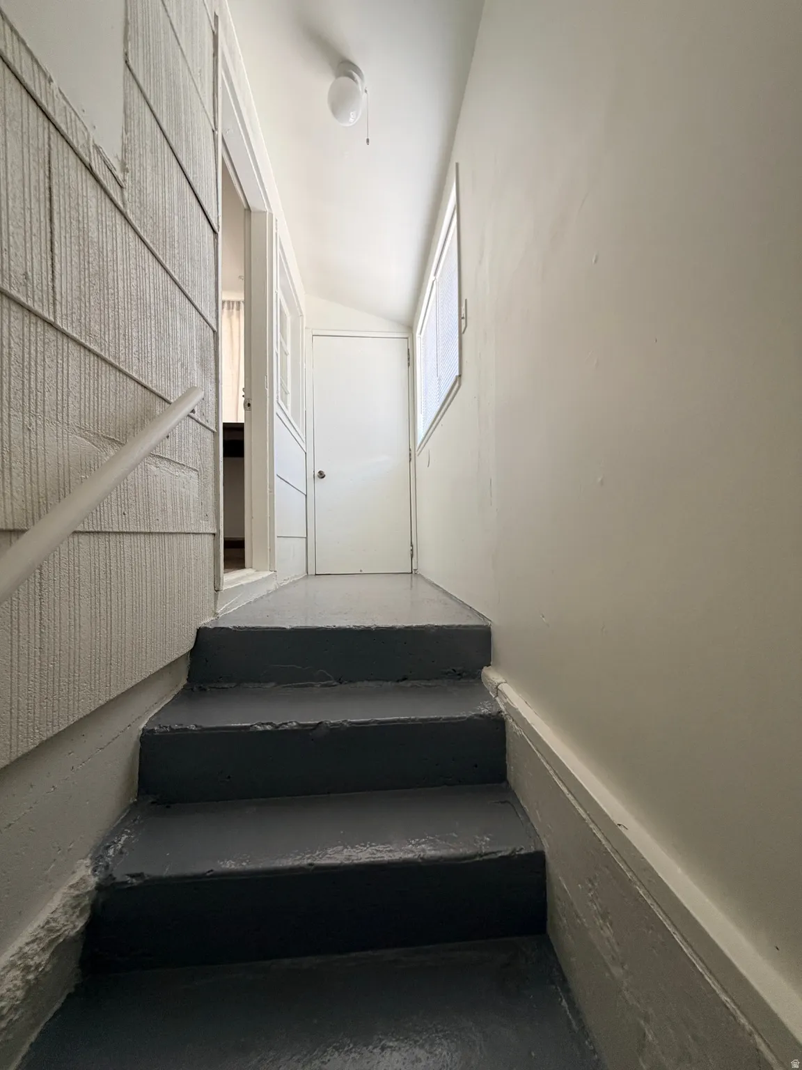 Entryway staircase featuring painted steps and a white handrail