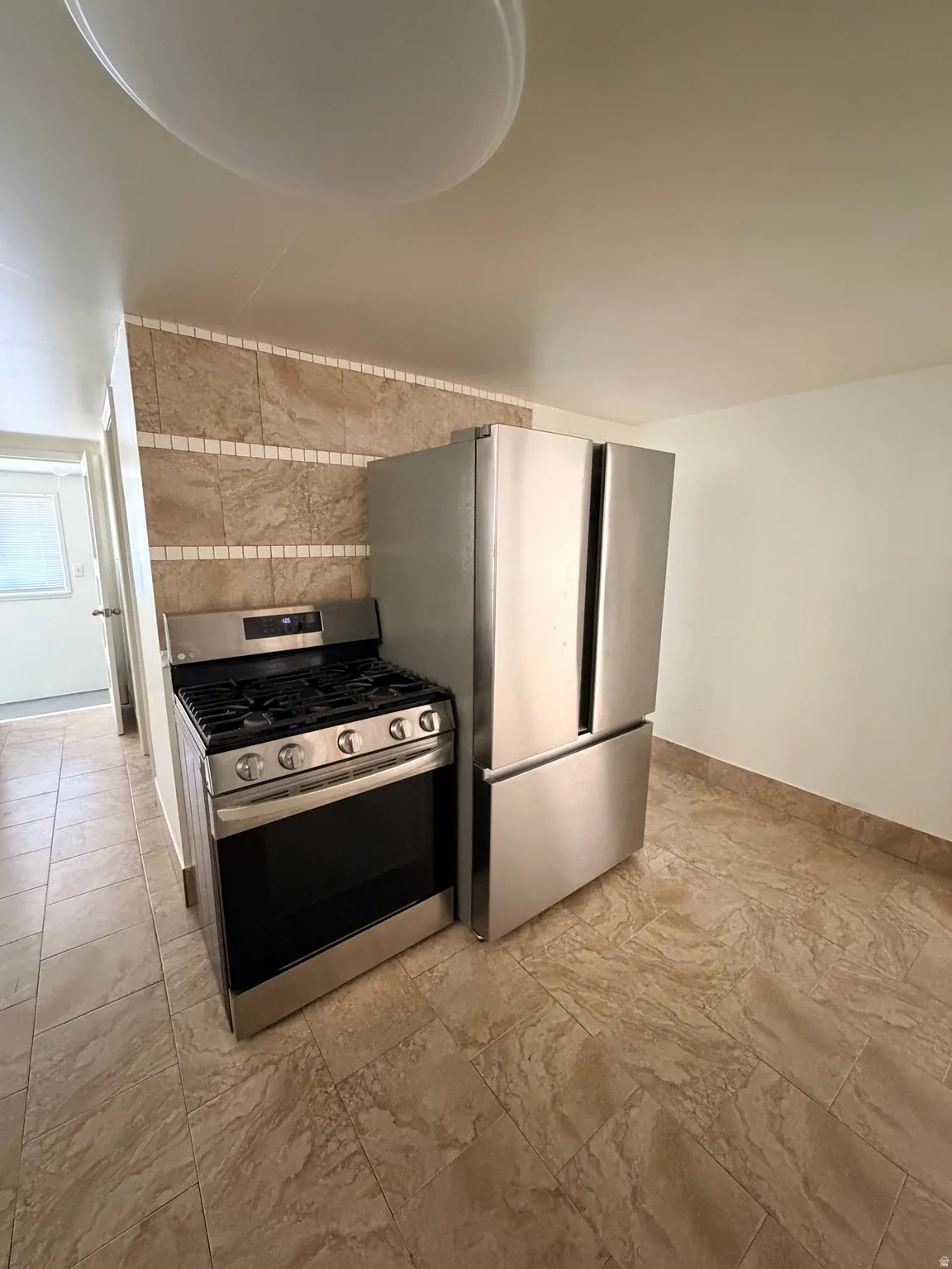 Stainless steel French door refrigerator and gas range with five burners