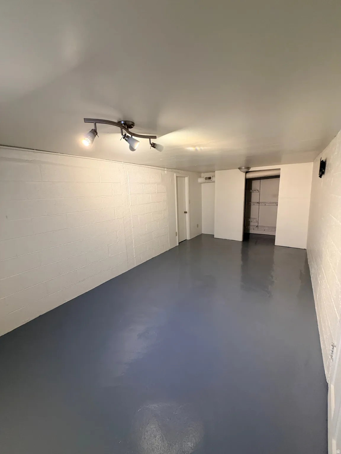 Spacious room with painted block walls and a finished floor
