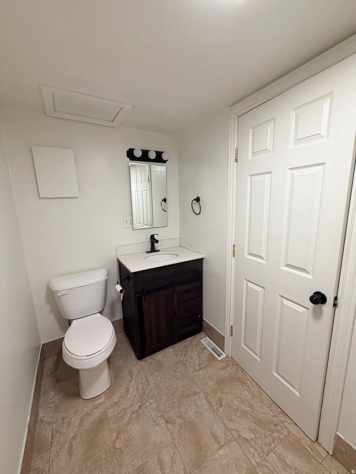 Bathroom featuring a dark wood-finish vanity with a white countertop and rectangular undermount sink