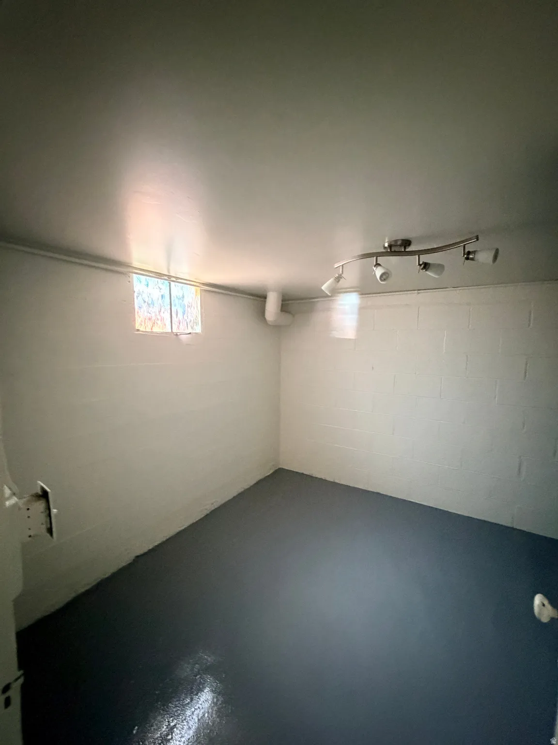 Painted concrete block walls featuring a small window