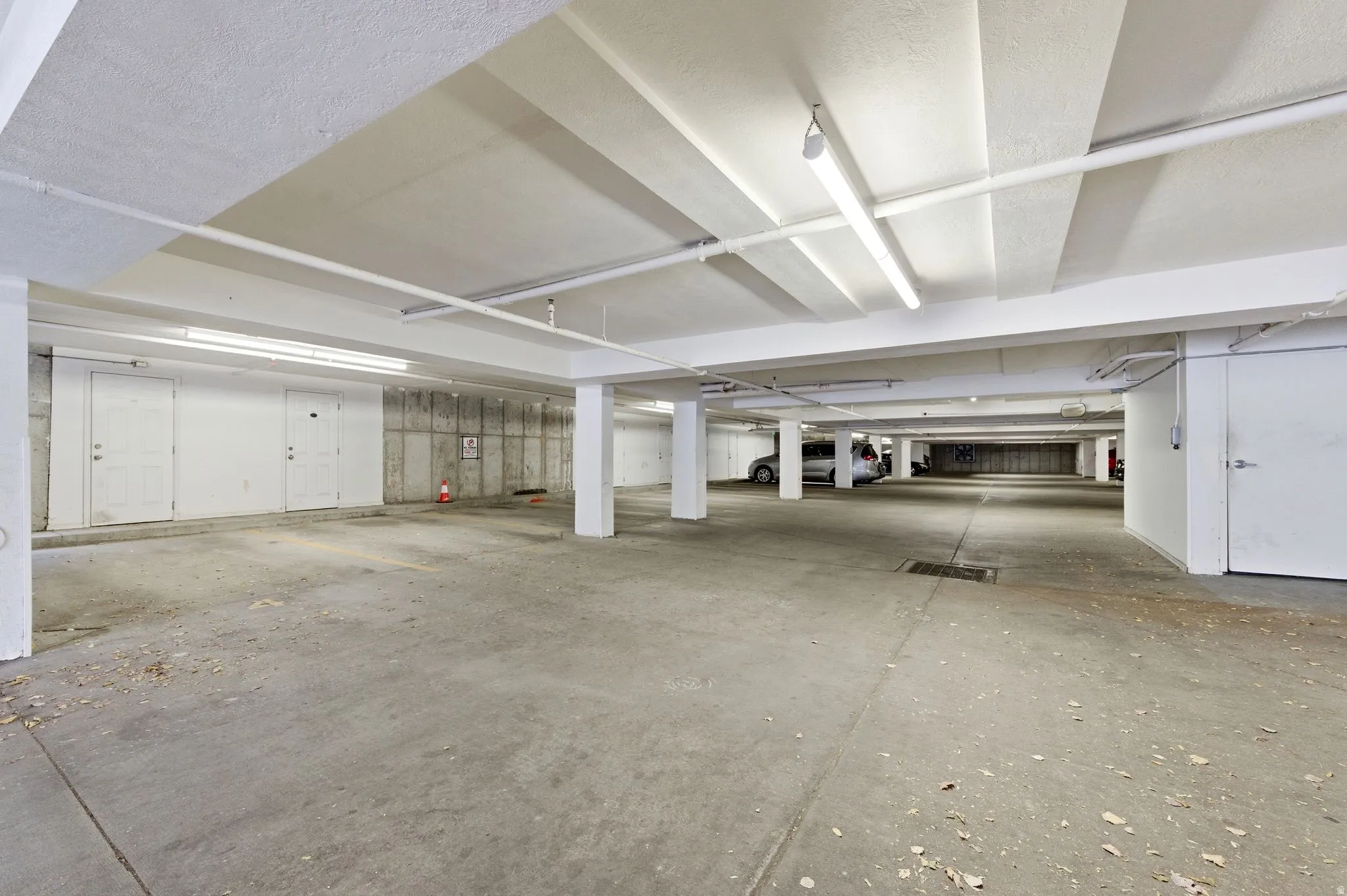 Underground parking facility featuring concrete flooring and exposed concrete structural walls