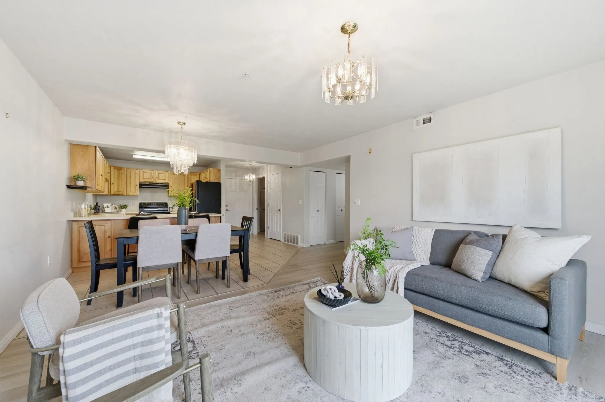 Open-concept living area with light-toned walls and wood-finish flooring
