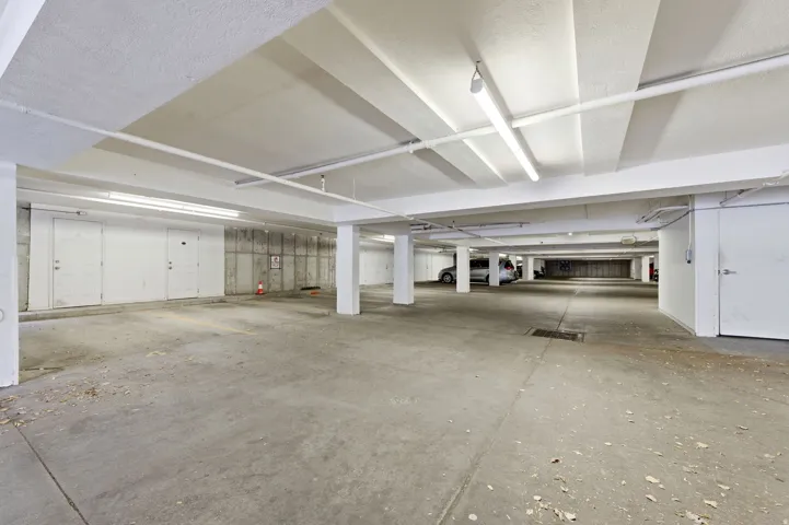 Underground parking facility featuring concrete flooring and exposed concrete structural walls