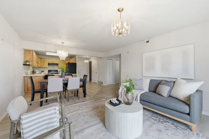 Open-concept living area with light-toned walls and wood-finish flooring