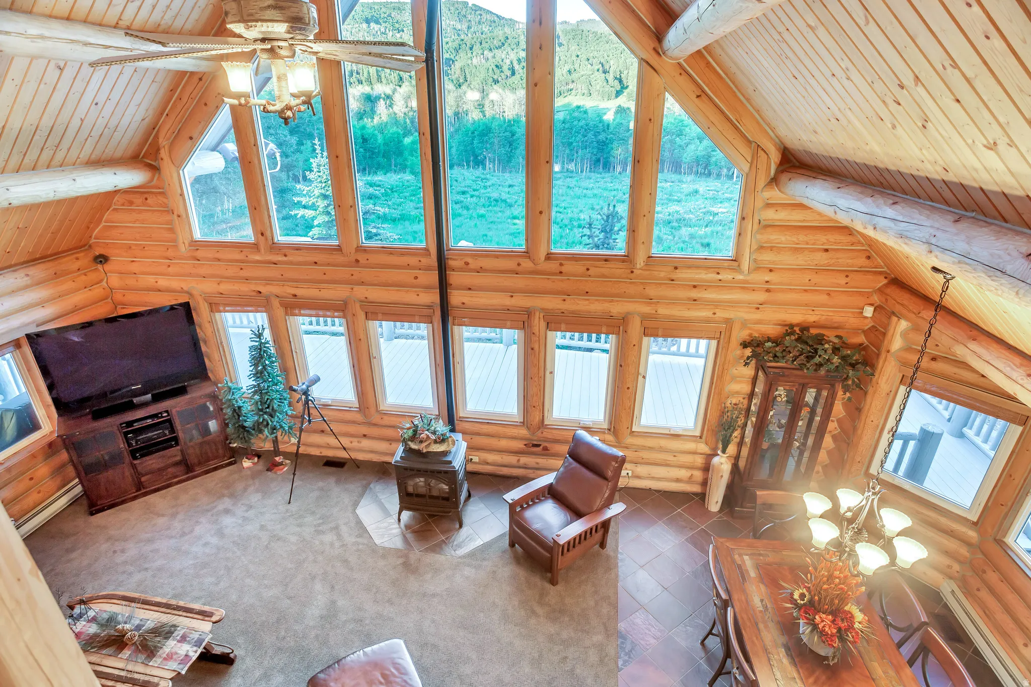 Vaulted living area featuring log construction and multiple large windows