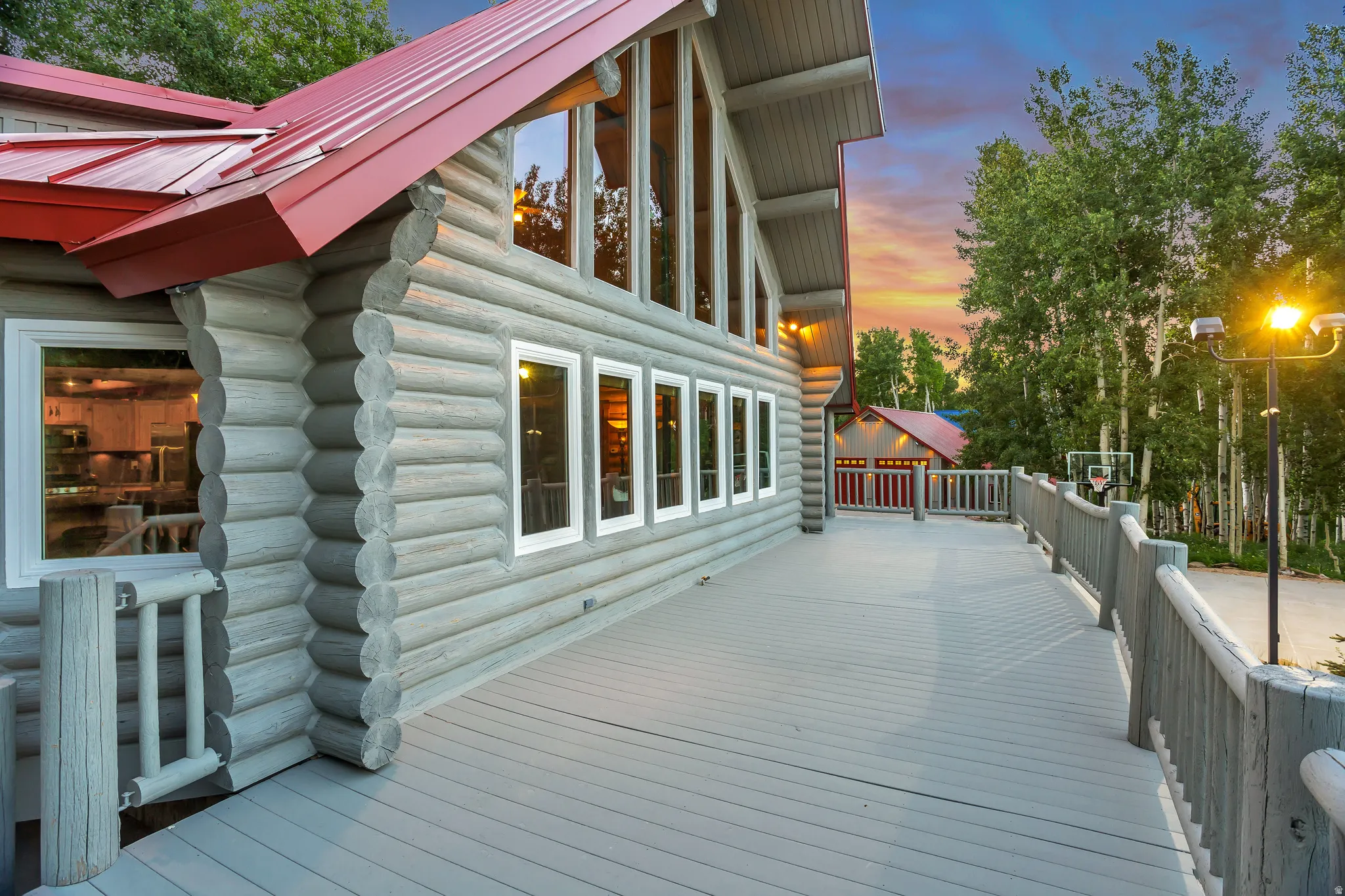 Expansive outdoor deck featuring log railing and a gray surface