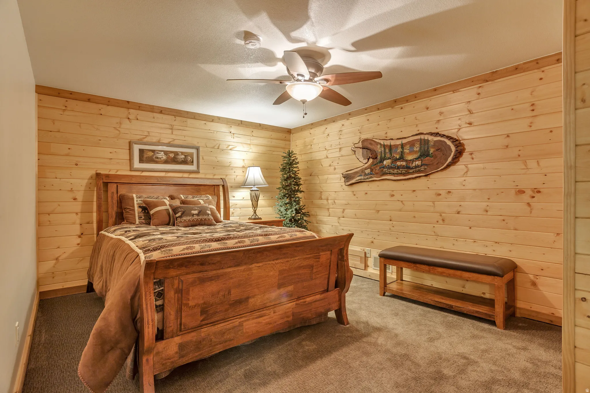 Wood-paneled room featuring a neutral carpet flooring and a ceiling fan with integrated lighting