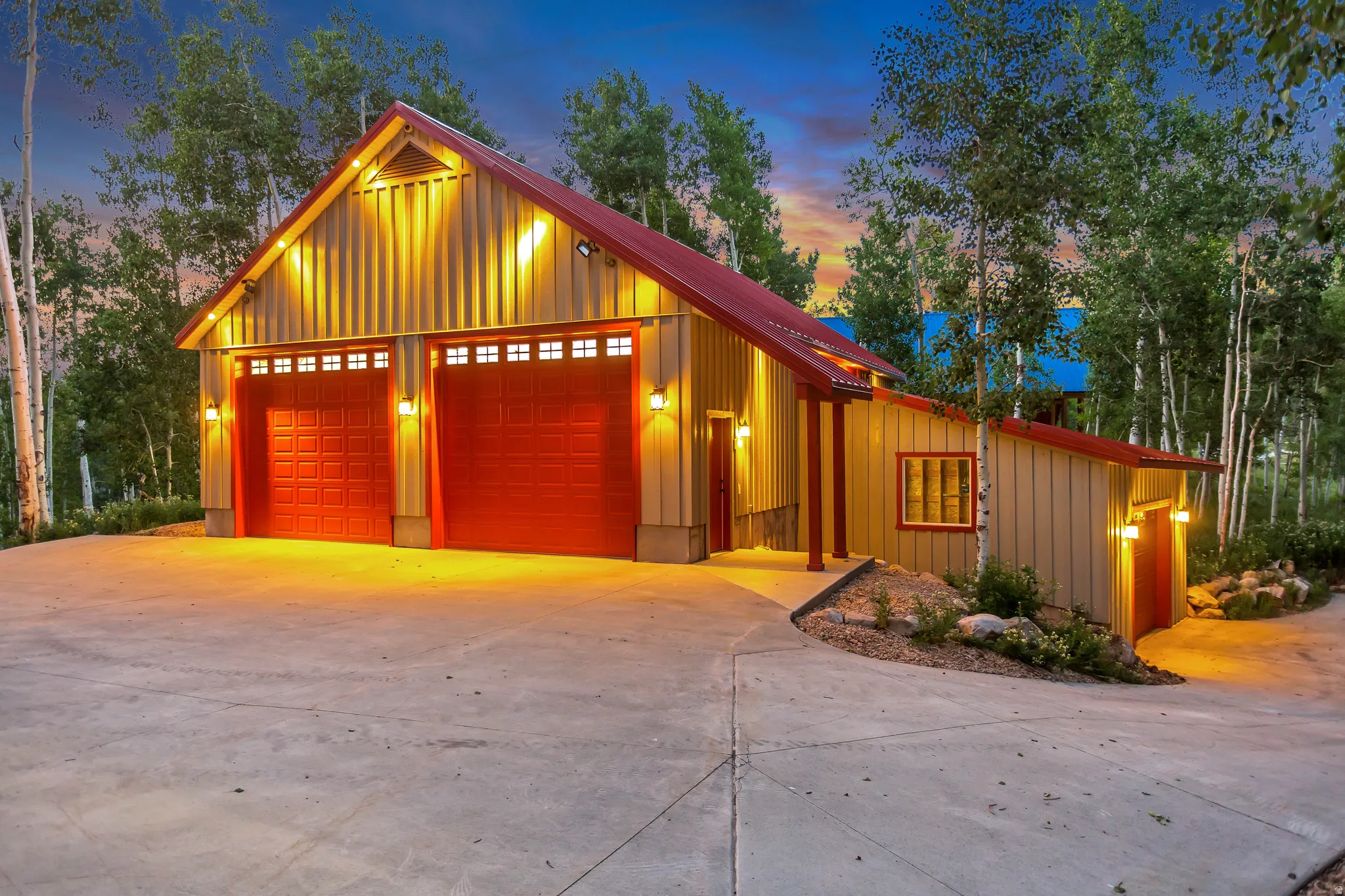Barn-style structure with a red metal roof and two large red garage doors