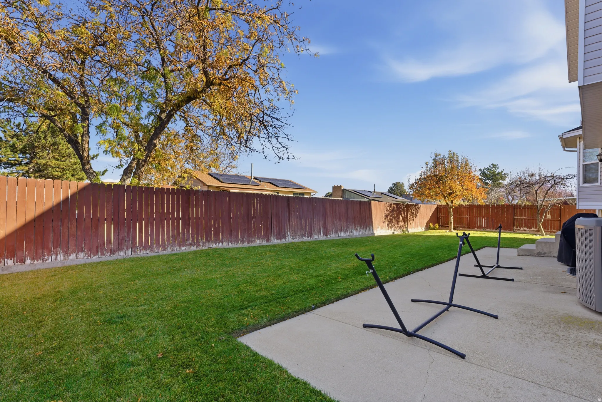 Expansive green lawn bordered by a wood privacy fence and mature trees