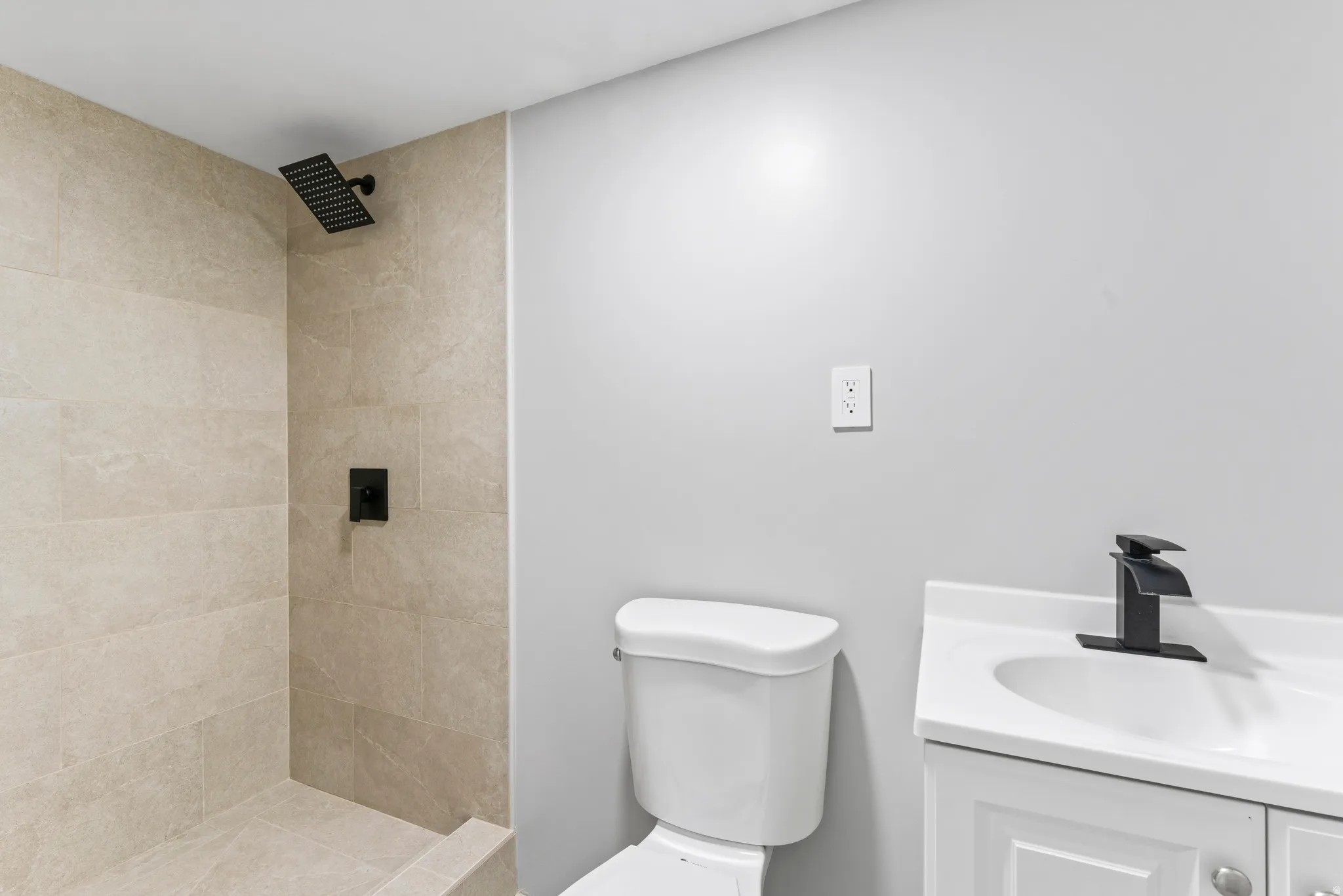 Walk-in shower with large format tile surround and rainfall showerhead