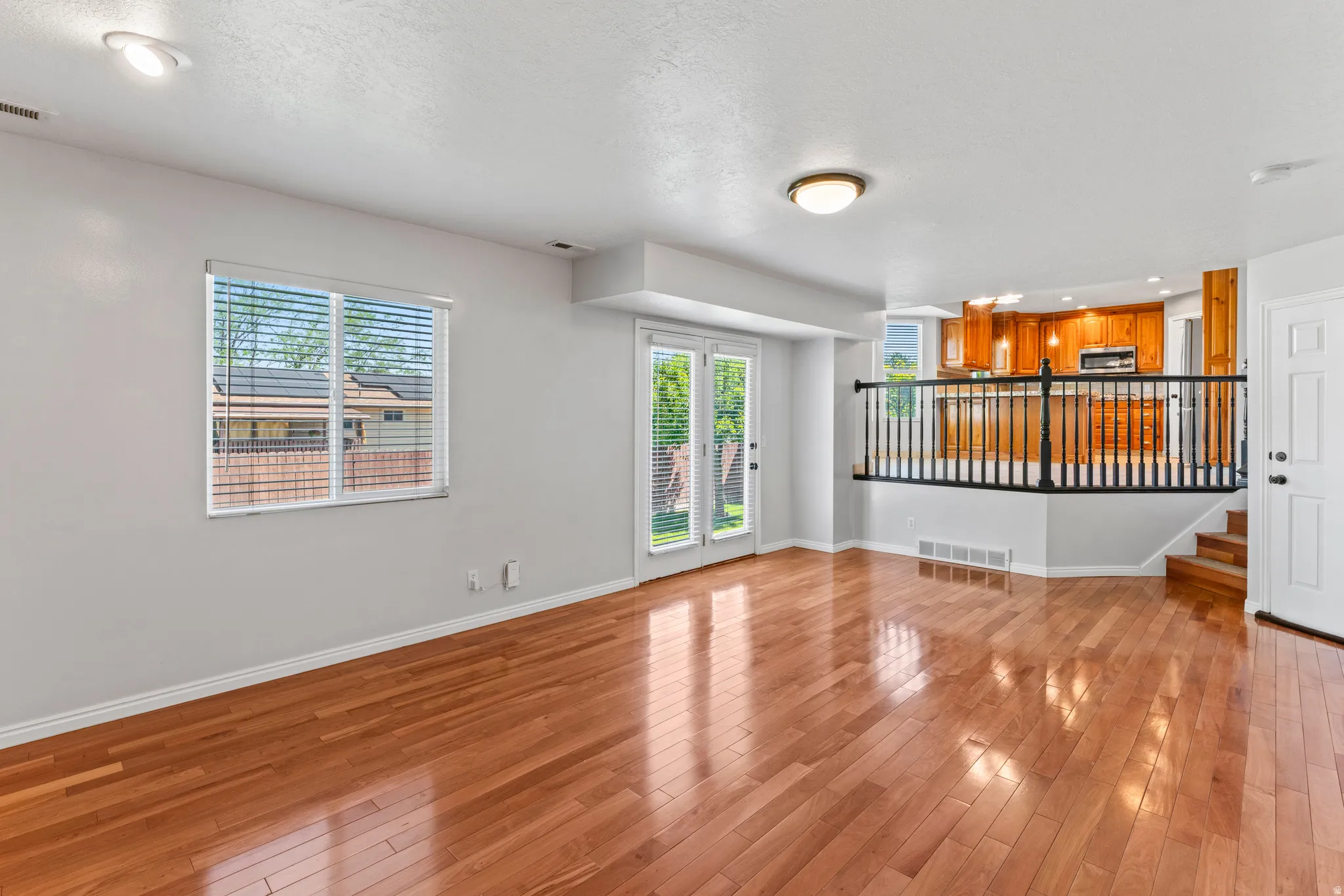 Spacious main living area featuring wood-finish flooring, white baseboards, and neutral wall paint