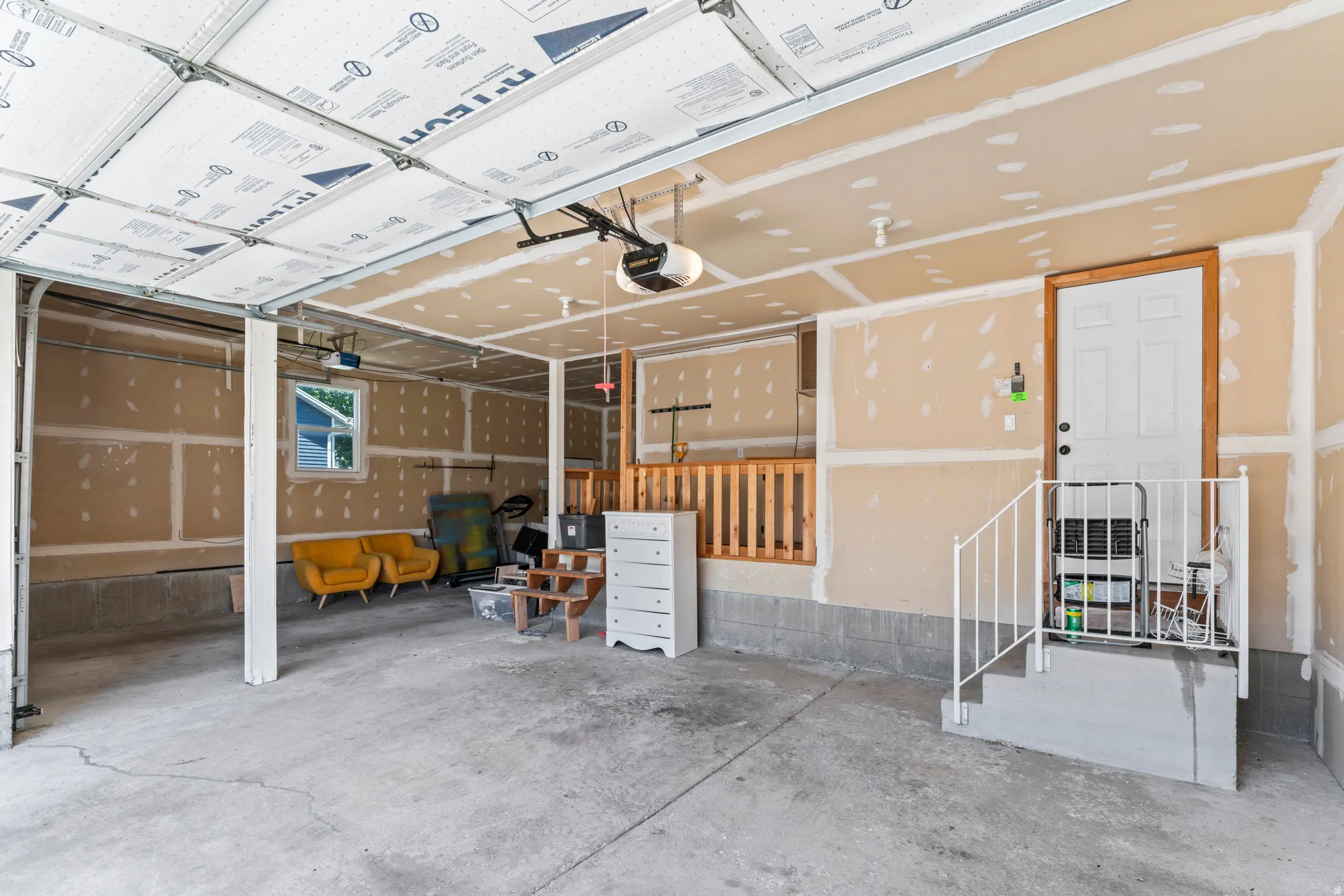 Spacious garage with concrete flooring and exposed drywall