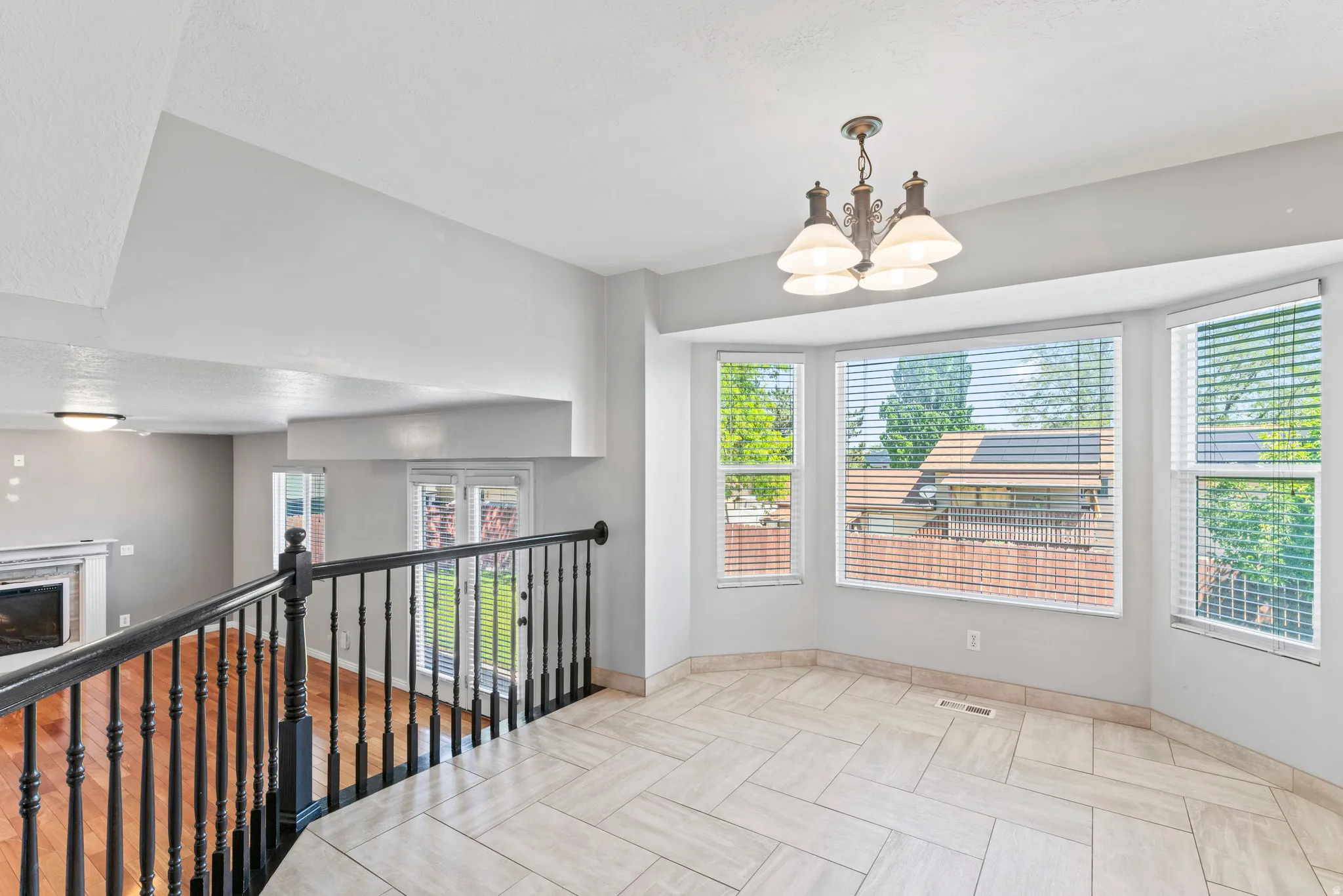 Bay window area featuring large format tile flooring and a chandelier