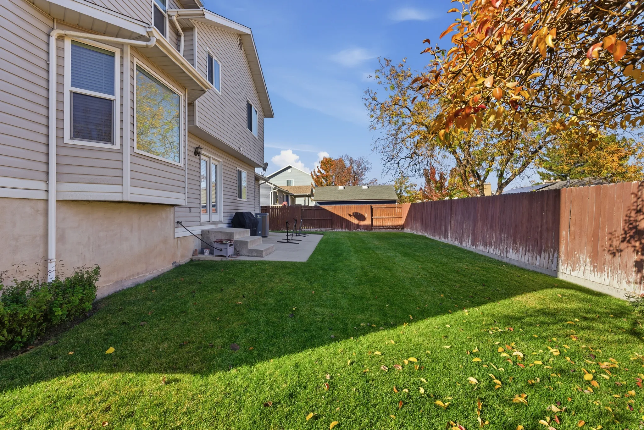 Expansive green lawn with a full privacy fence