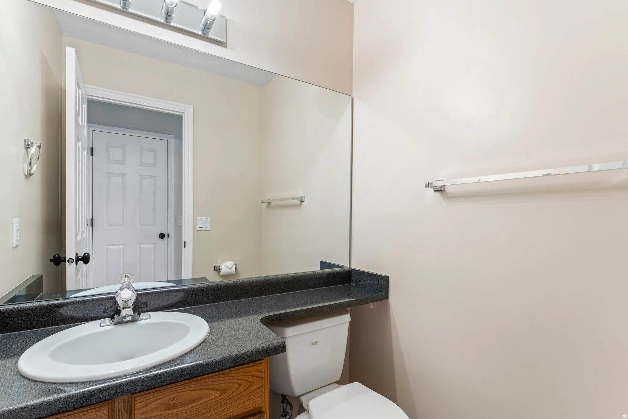 Bathroom vanity with a dark countertop and integrated sink