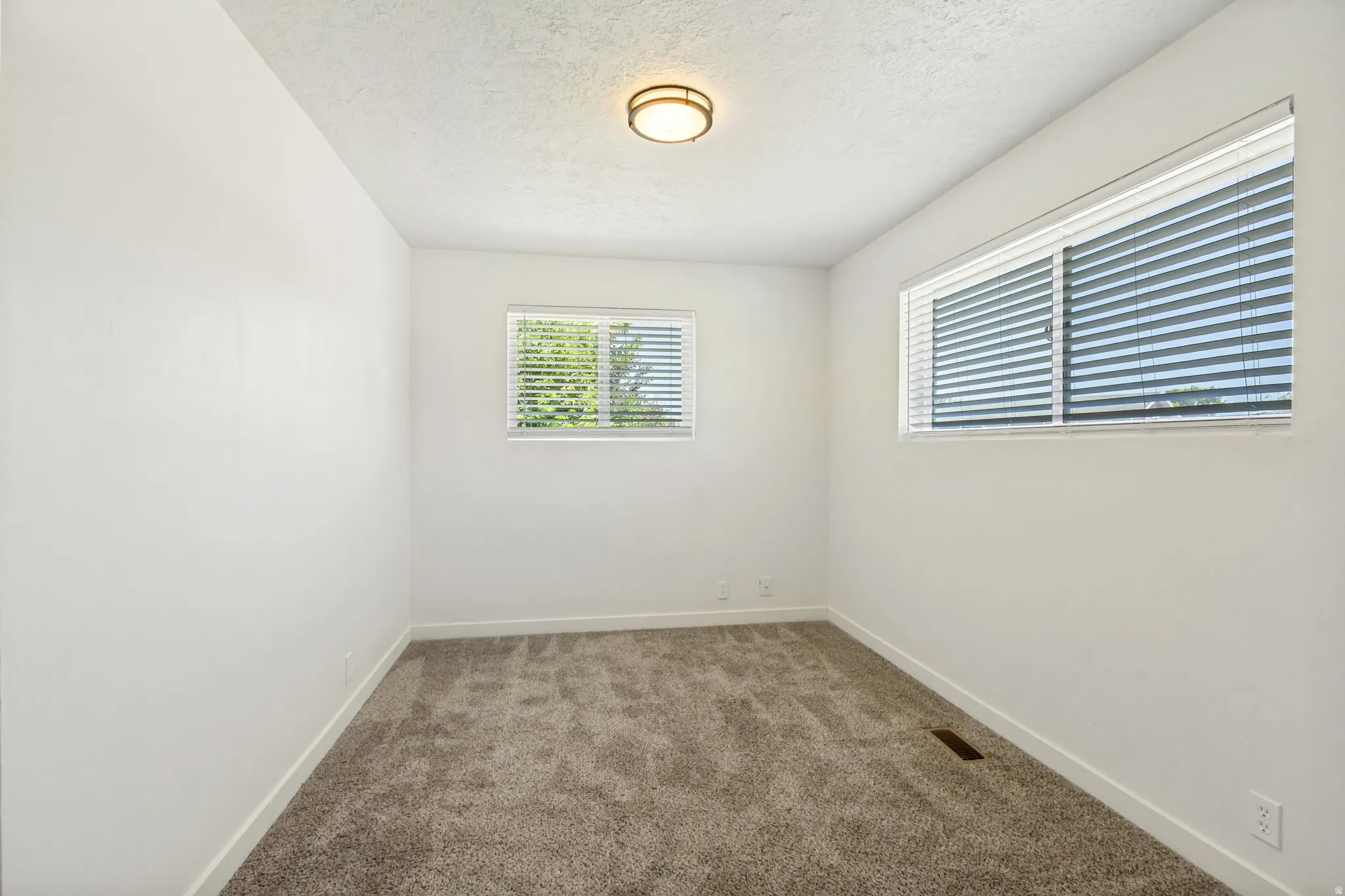 Neutral-toned wall-to-wall carpeting complements the white walls and trim