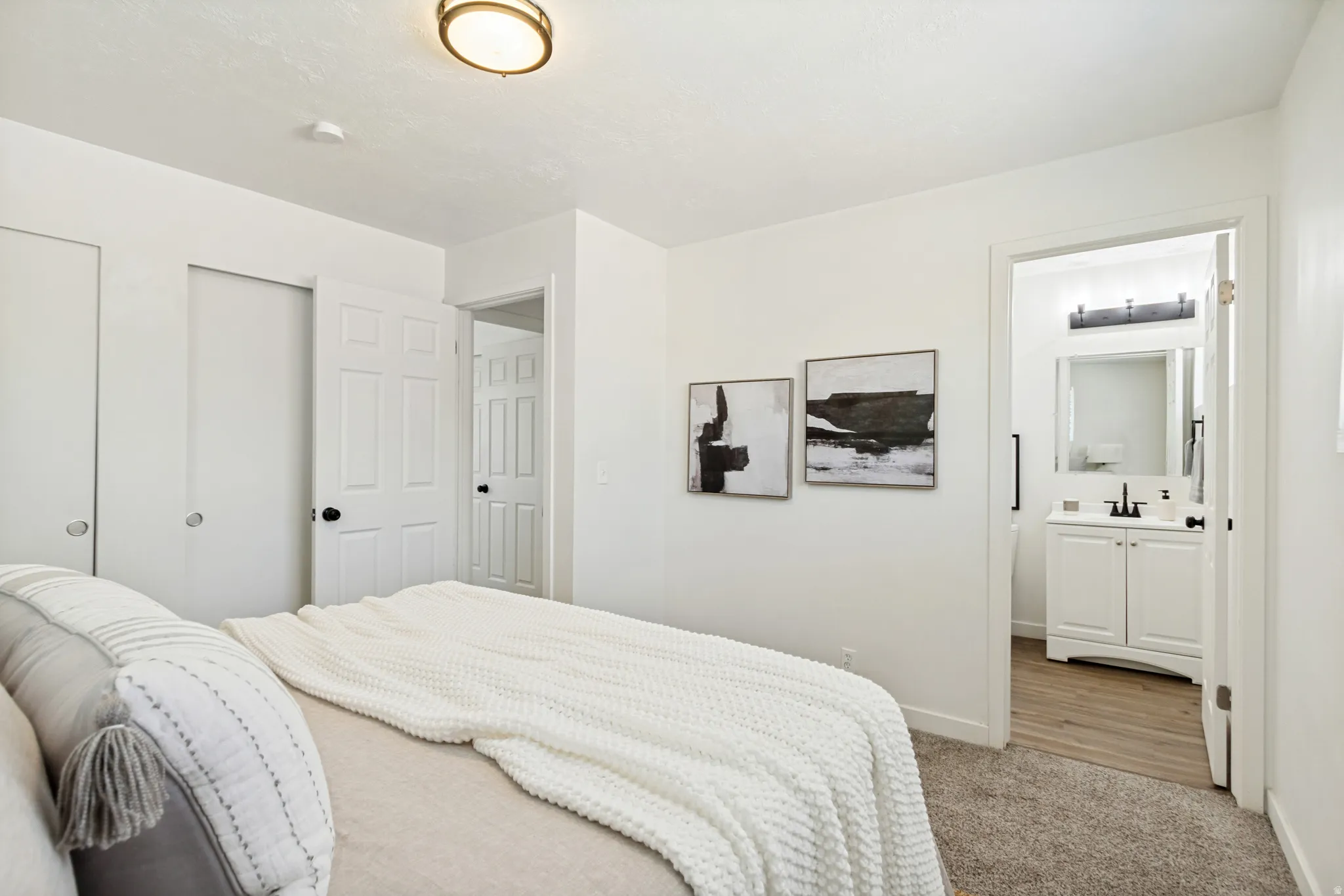 Plush carpeted room featuring a ceiling-mounted light fixture, white interior doors with black hardware, and a sliding closet door