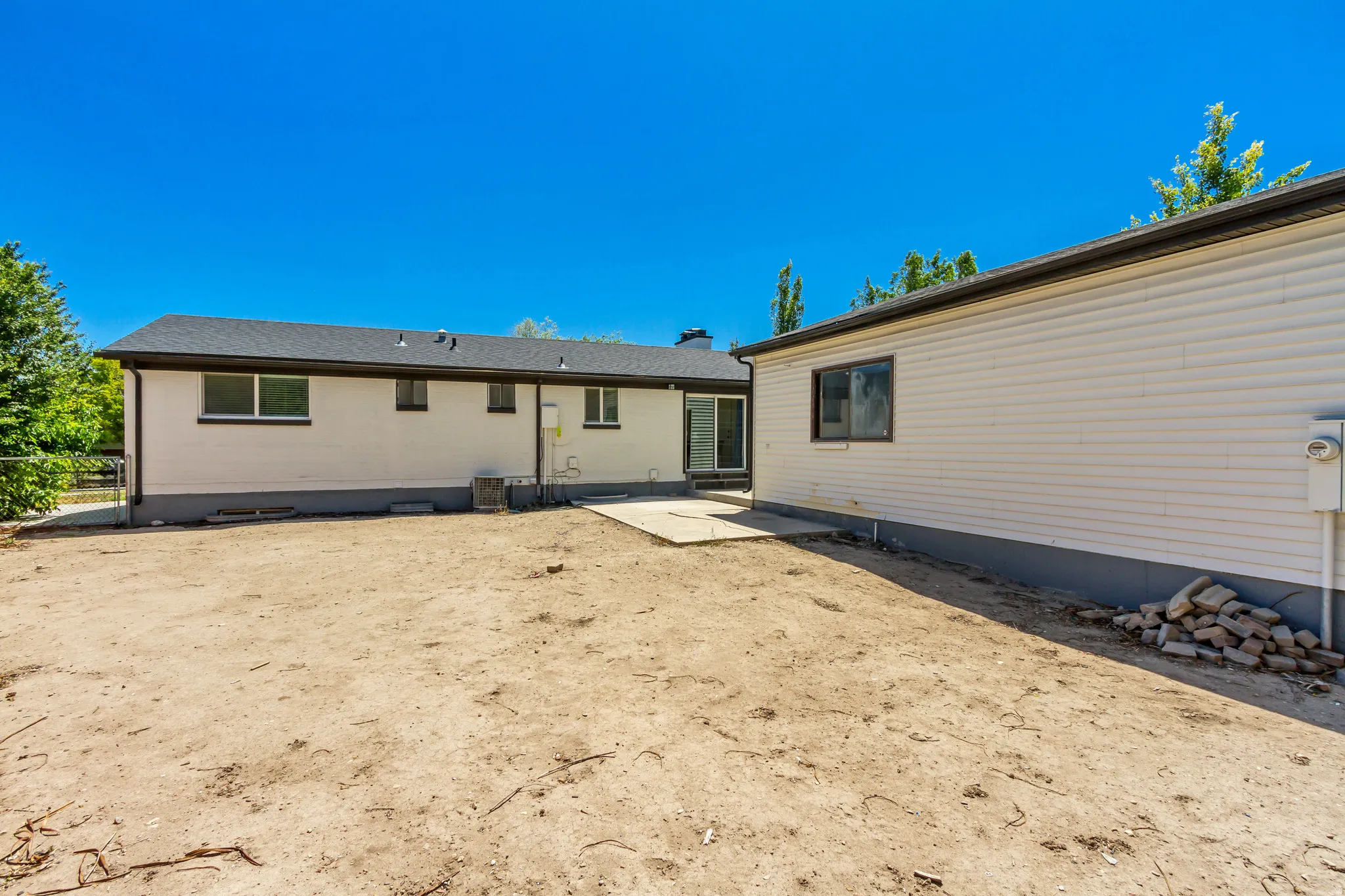 Expansive rear yard with a concrete patio pad, offering space for customization