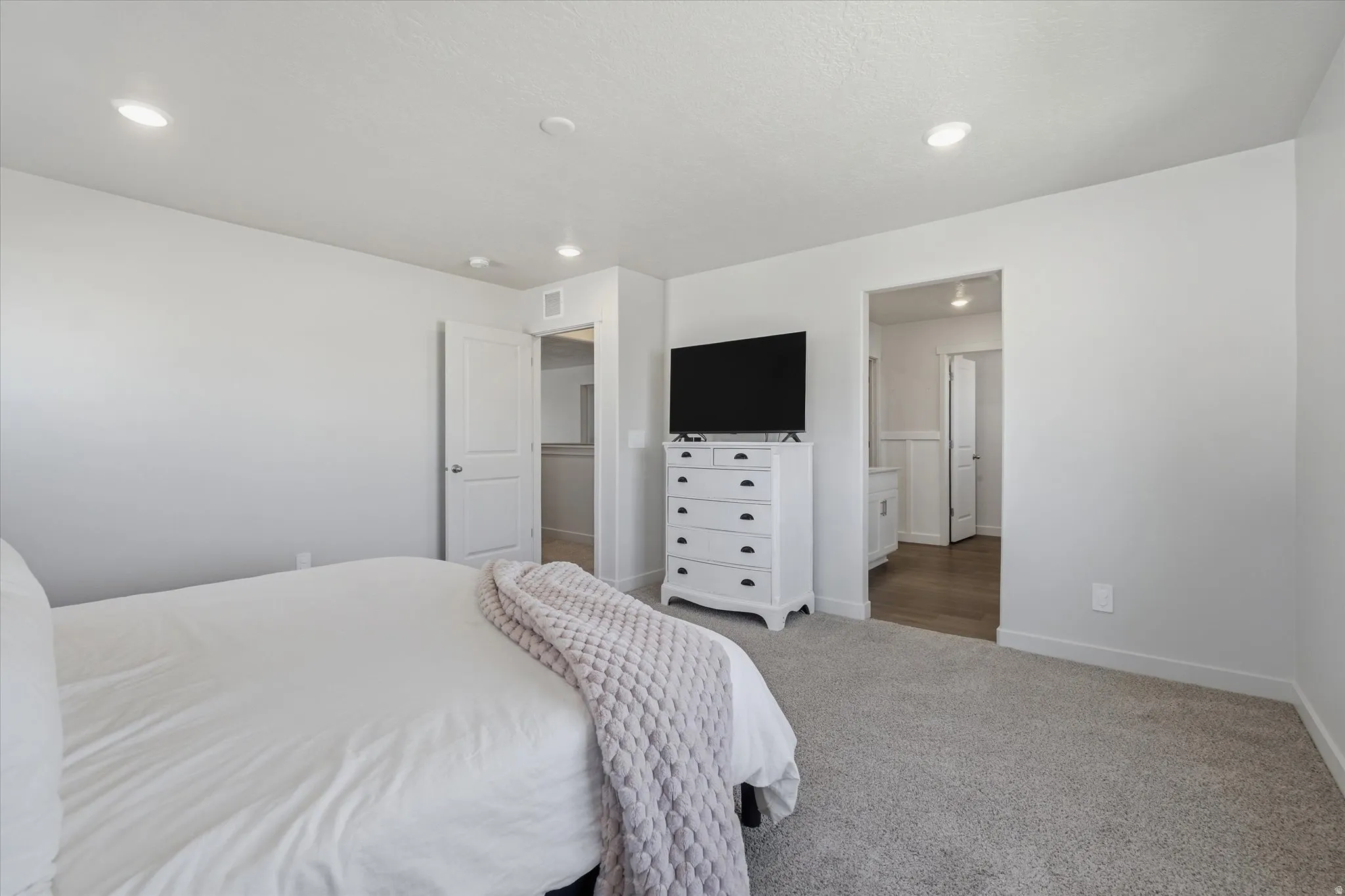 Carpeted room with recessed lighting and a neutral wall color