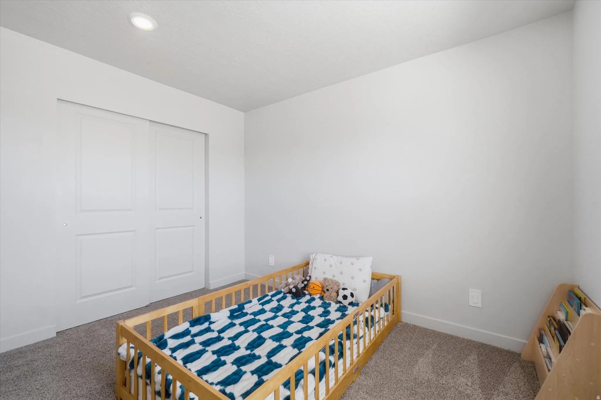 Neutral wall paint, recessed ceiling lighting, and carpet flooring
